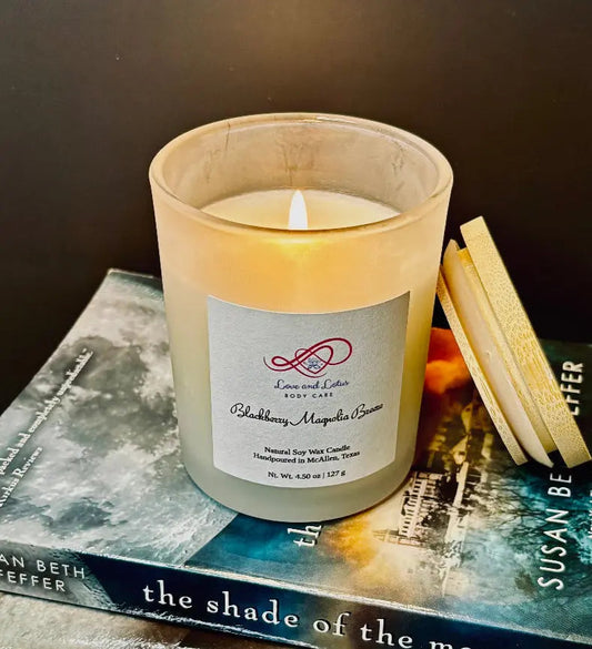 handmade candle burning sitting on top of a book